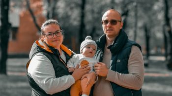 a man and woman holding a baby